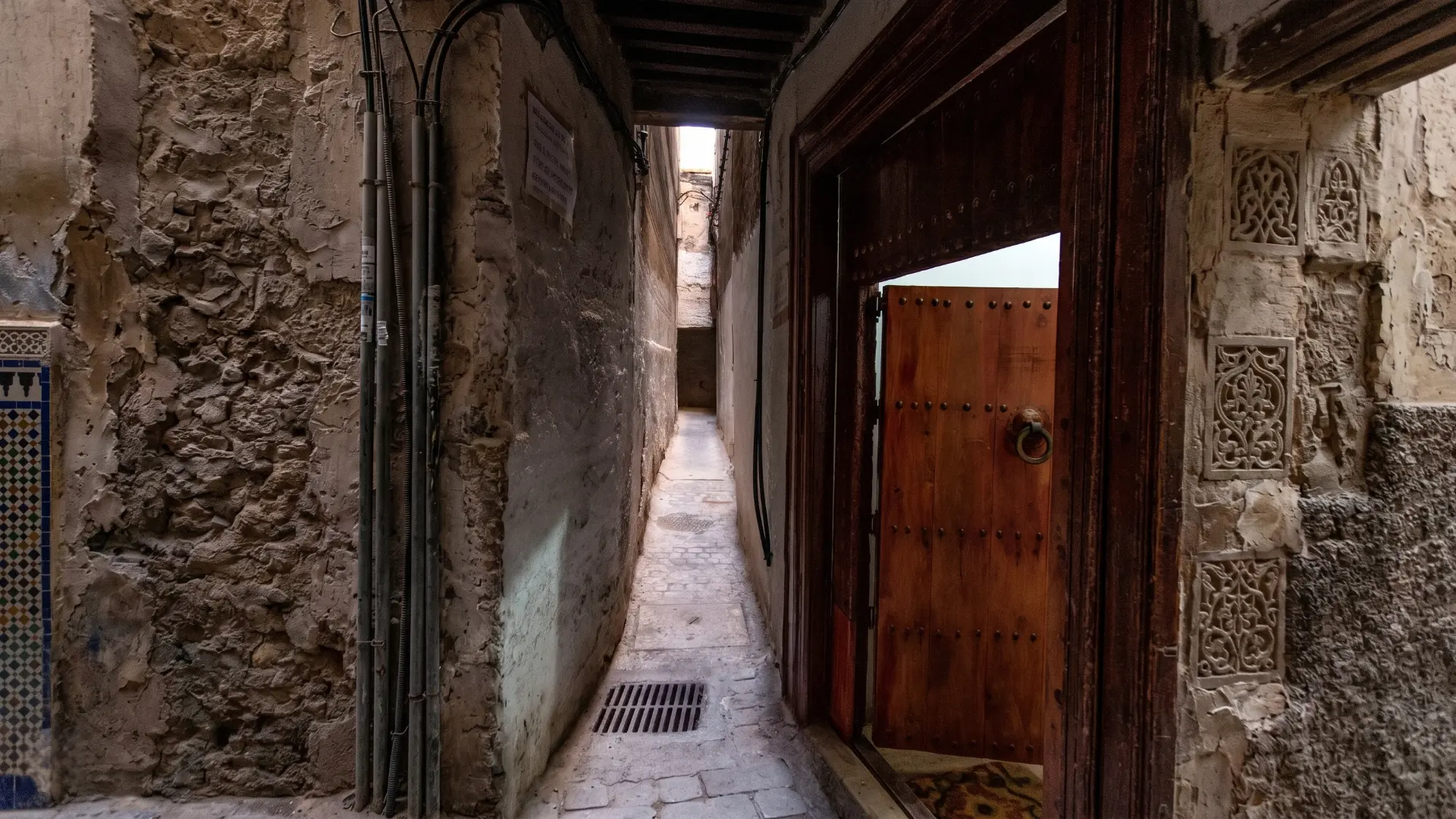 Narrow Historic Alley Fez Medina | Authentic Streets & Doors Morocco Charming narrow stone alleyway in the old Fez Medina with traditional carved wooden door
