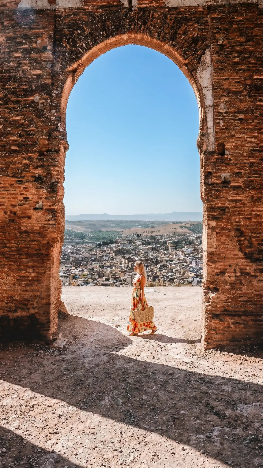 Panoramic Medina View from Marinid Tombs Fez | Iconic Overlook Morocco Woman in floral dress at ancient brick arch overlooking the sprawling Fez Medina and hills in Morocco