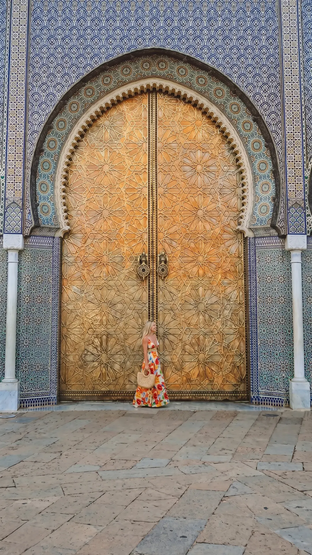 Massive Carved Wooden Doors Fez Morocco | Royal Palace Entrance Woman standing beside enormous intricately carved golden wooden doors with blue zellige tiles in Fez