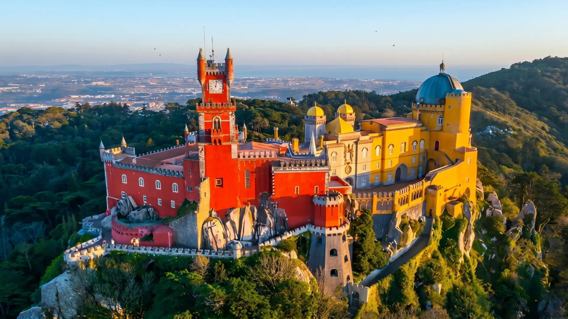 Colorful Pena Palace overlooking misty Sintra forest trails Colorful Pena Palace overlooking misty Sintra forest trails